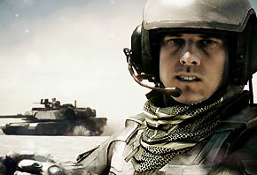 A Screenshot from video game Battlefield 3 of a gear-clad soldier in the dessert with a tanker behind him.