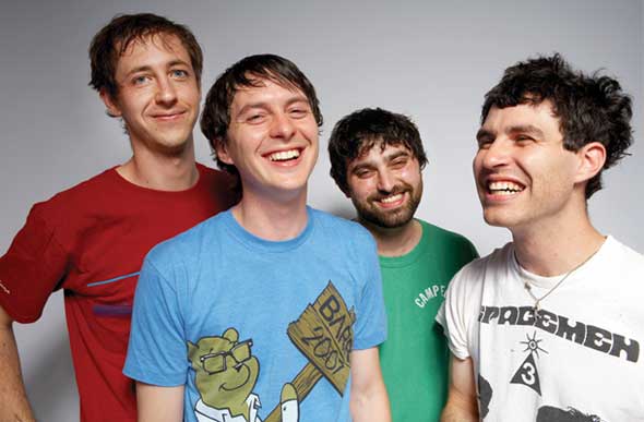 A close up casual portrait of Animal Collective where all the band members are happily smiling.